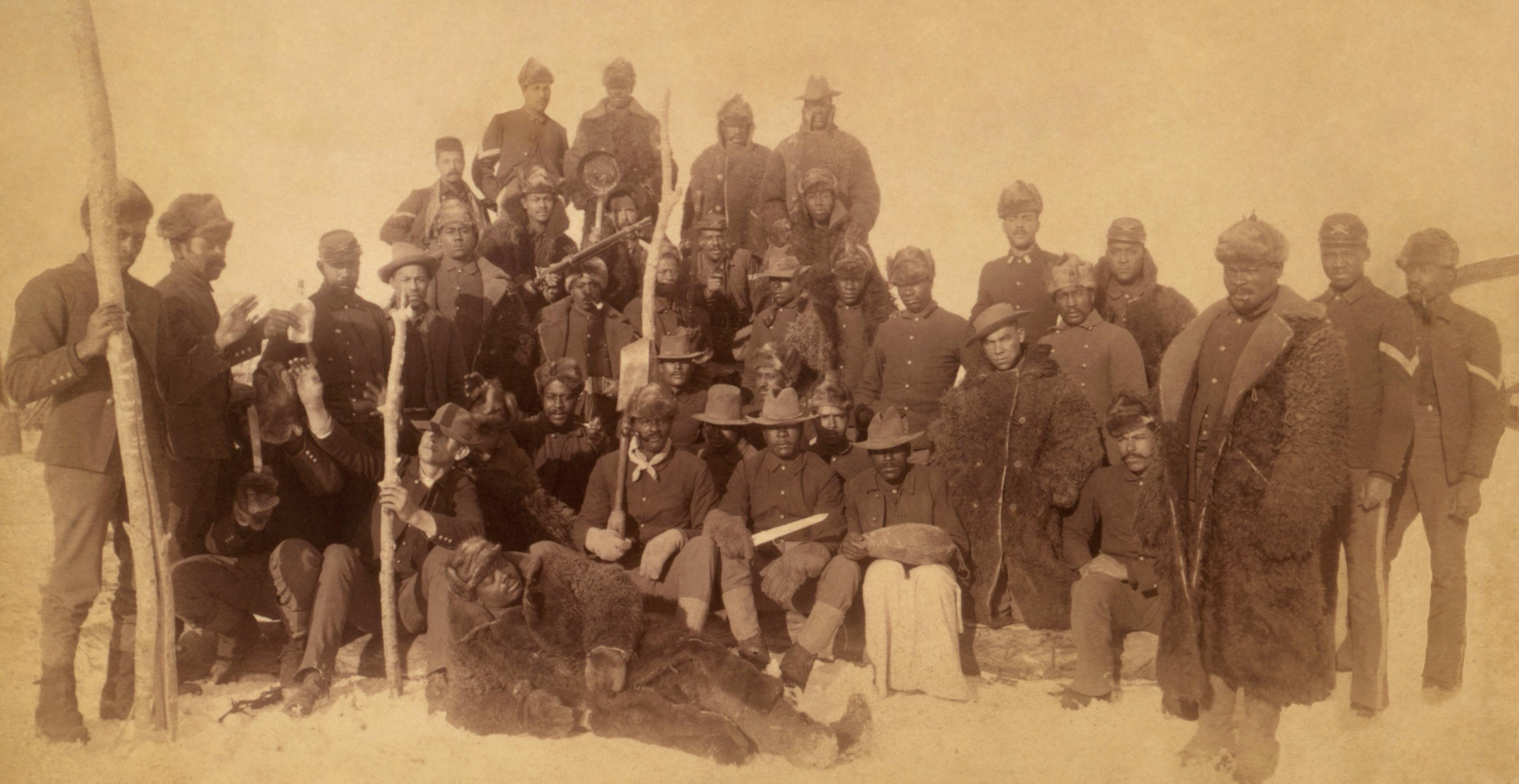 Several African American soldiers standing and sitting for a casual portrait