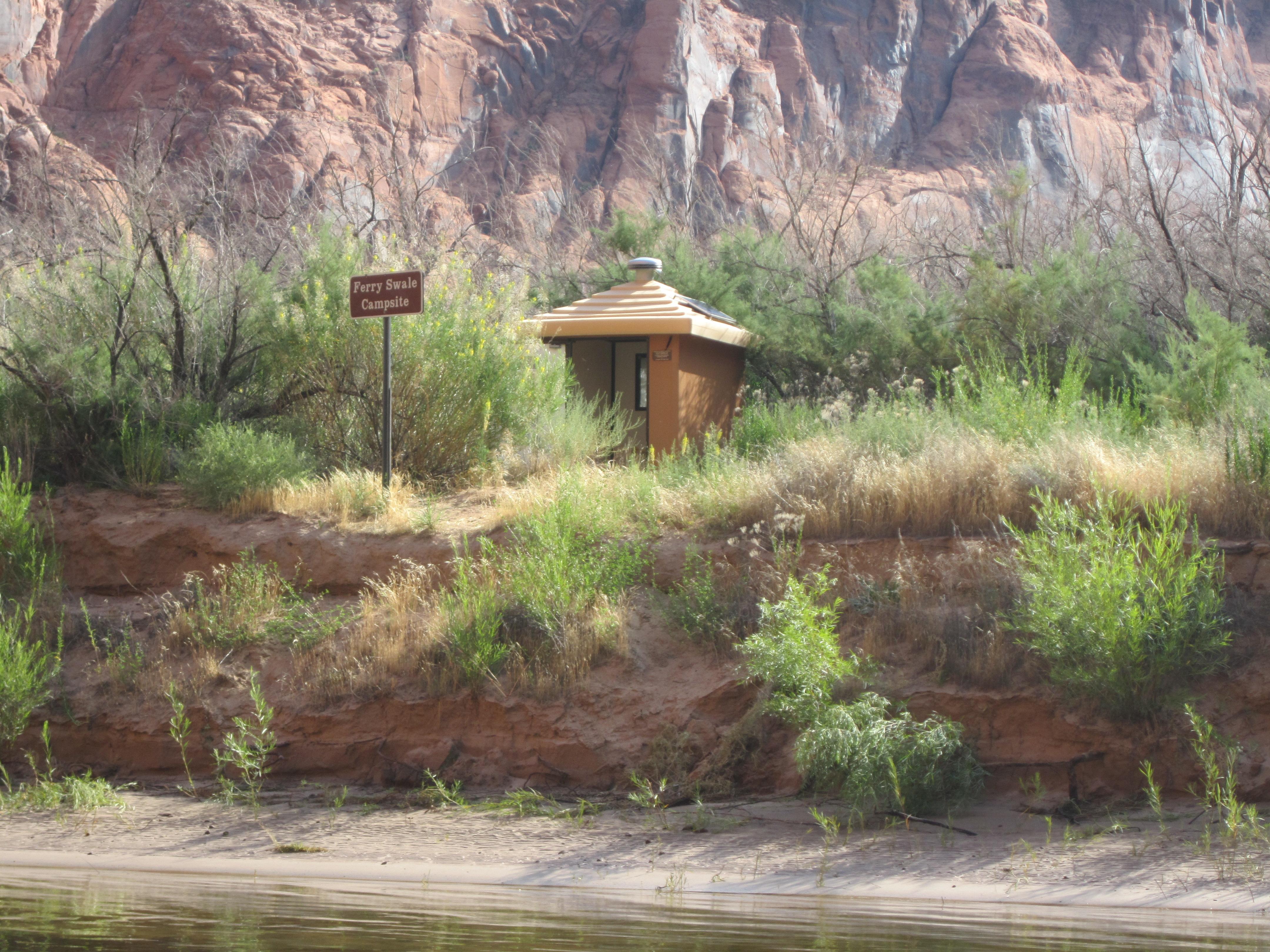 River beach with shrubs and vault toilet