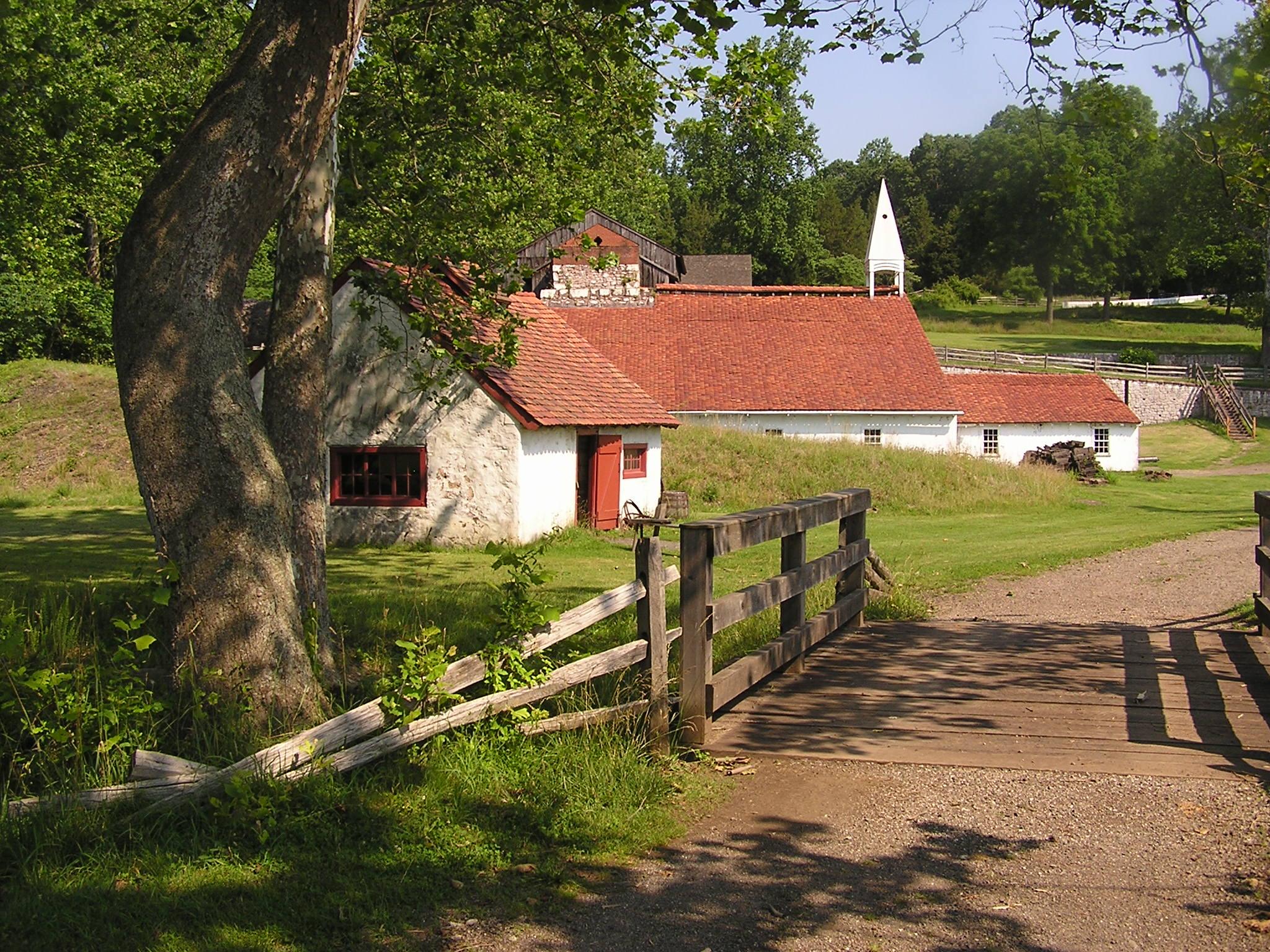 Side view of blacksmith shop with cast house behind it.