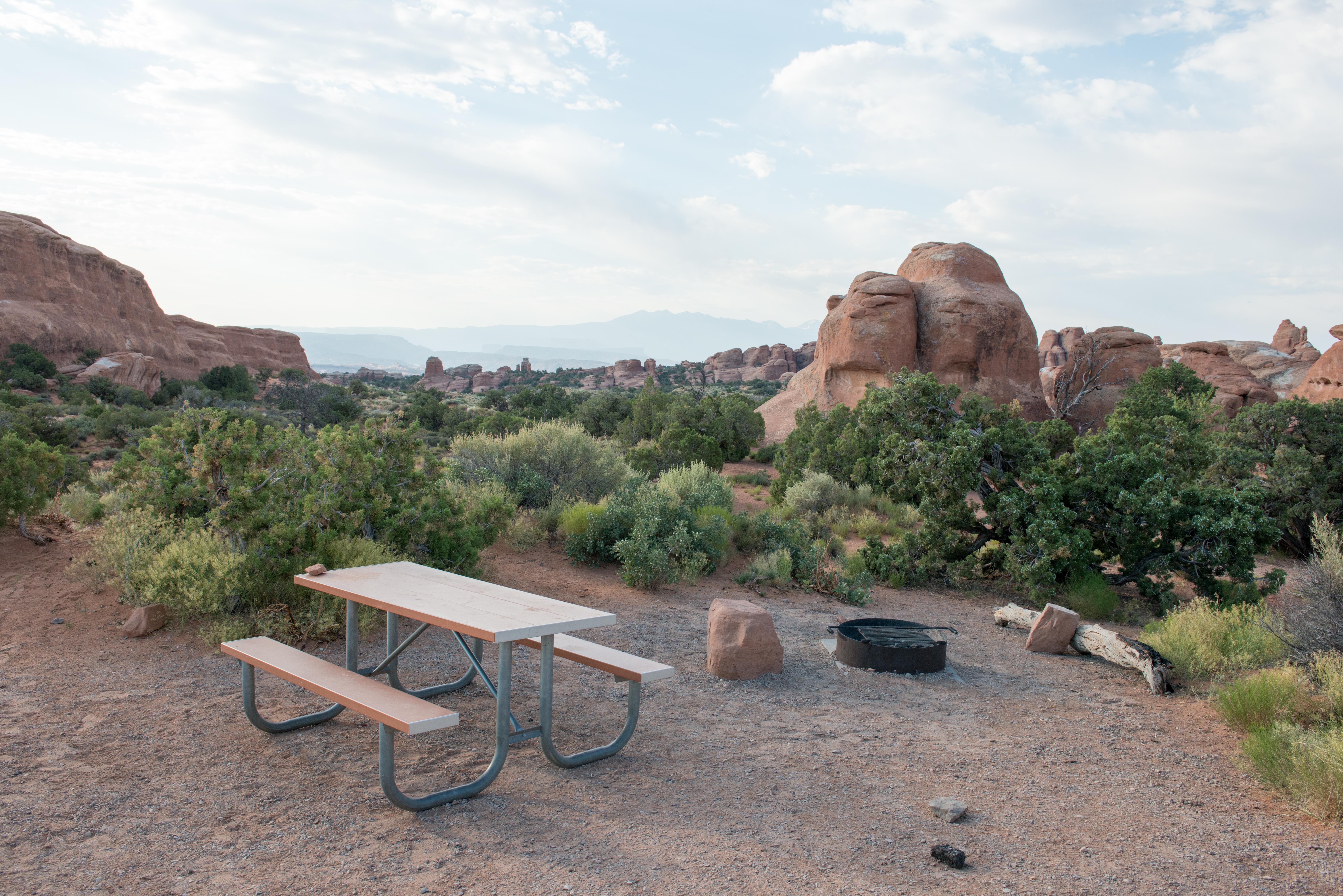 a campsite with picnic table and fire ring