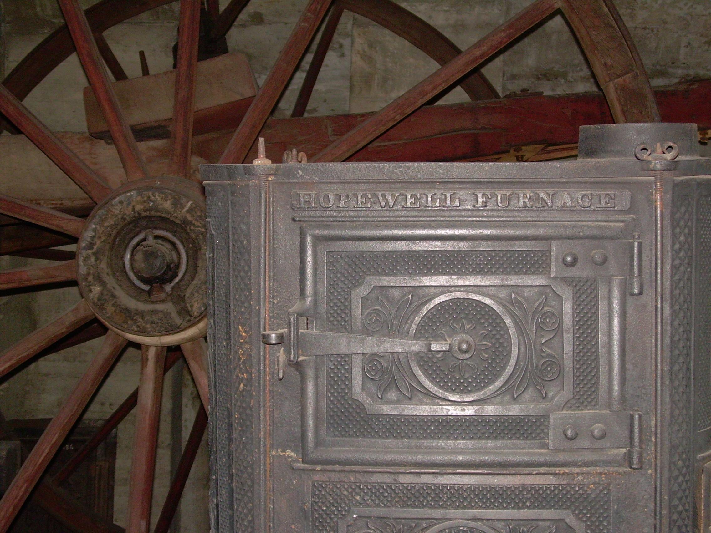 Side view of Hopewell Stove in front of wagon running gear.