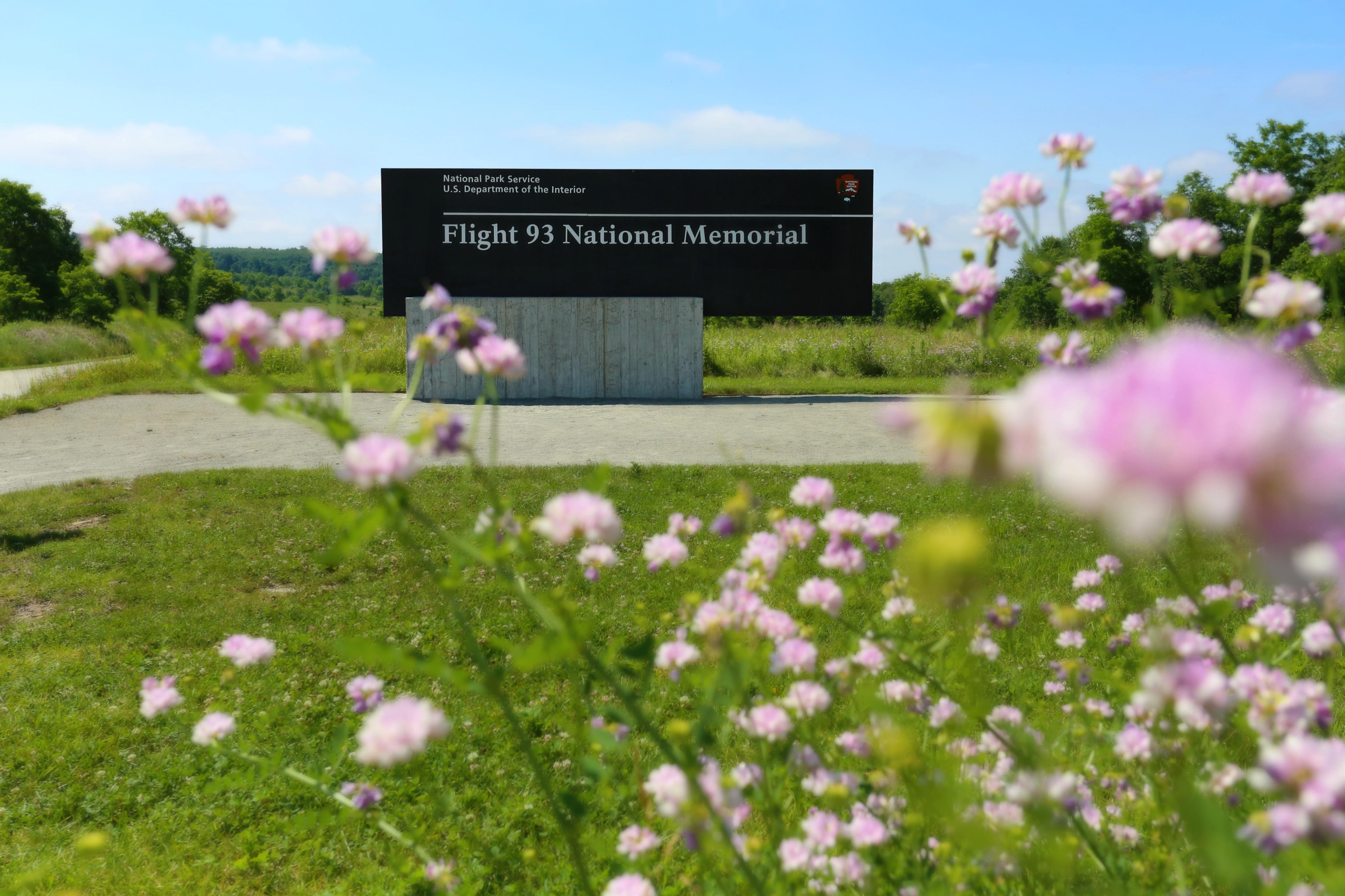 The memorial entrance sign with wilflowers.