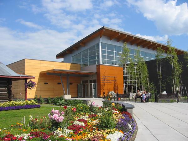 View showing the entrance to a large two-story, wood, glass, and steel building.