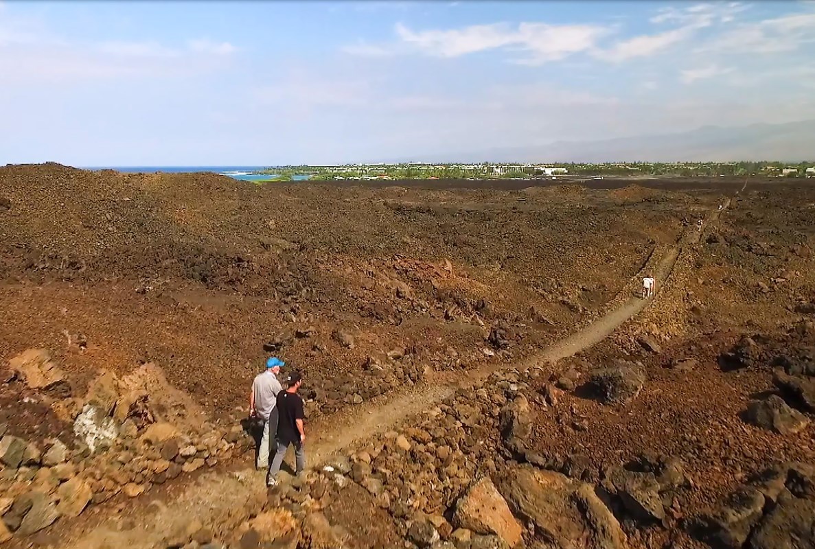 Aerial photograph of hikers along straight rocky segment of Ala Kahakai