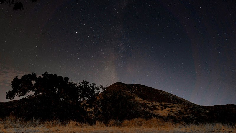 Paramount Ranch Night Sky Milky way shines in night sky over a mountain and oak tree.