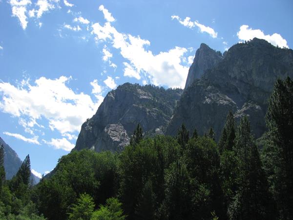 Rocky cliffs tower above a pine and cedar forest