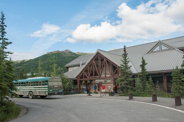 a bus parked outside a large building in a forest
