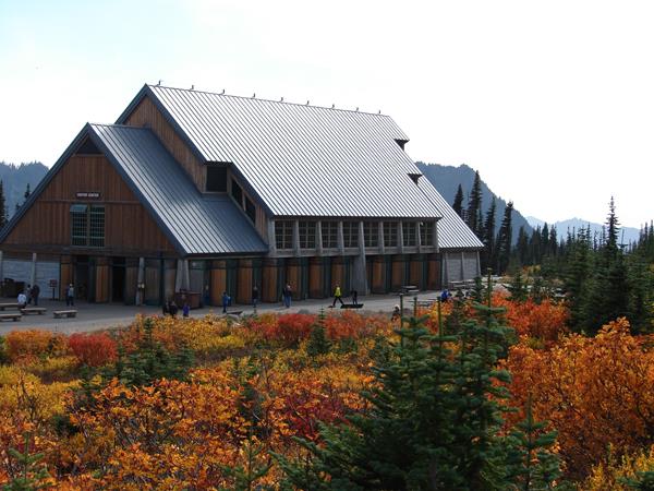A large building sits surrounded by the bright reds, oranges and yellows of fall.