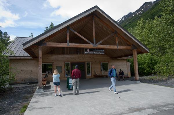 The front of a brown colored building with visitors outside