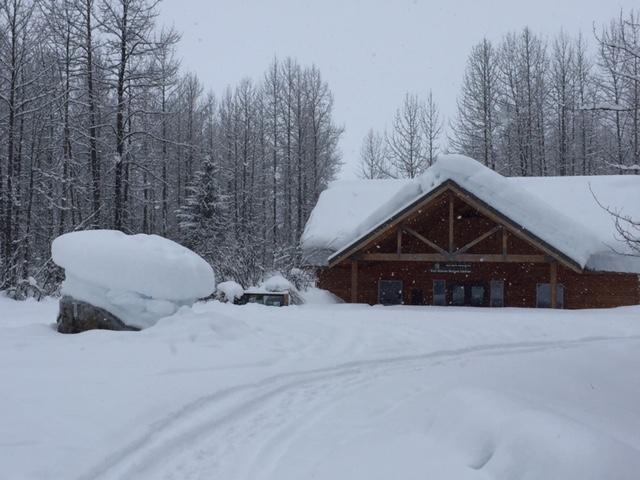 A brown building and sign covered in deep snow.