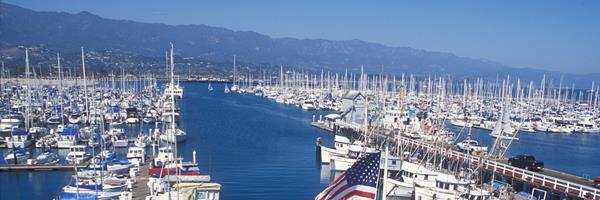 View of harbor with boats and tall mountains.