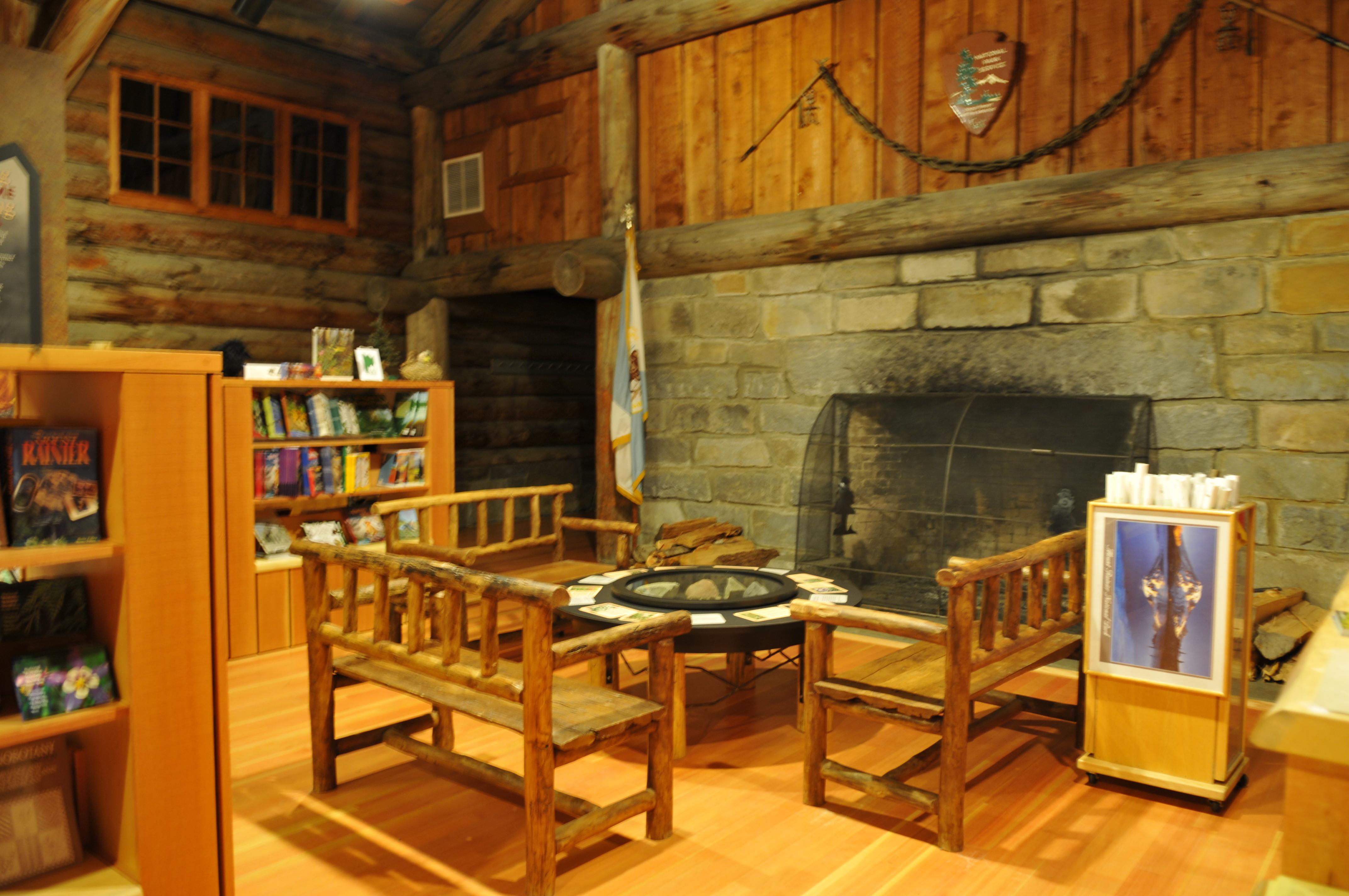 Rustic seating and sales racks around a large rock fireplace.