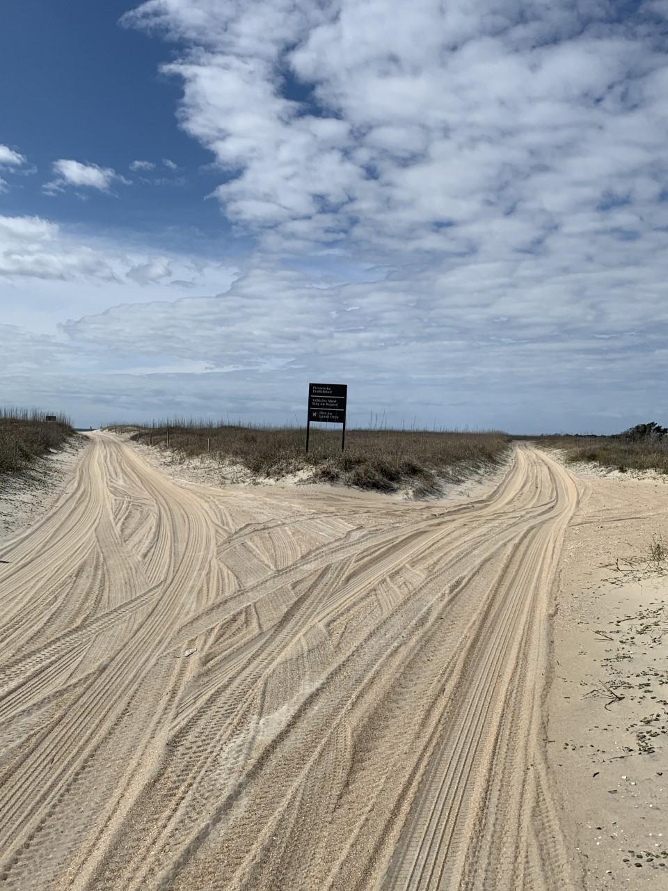 a sand trail on the island shows the tracks of vehicle use