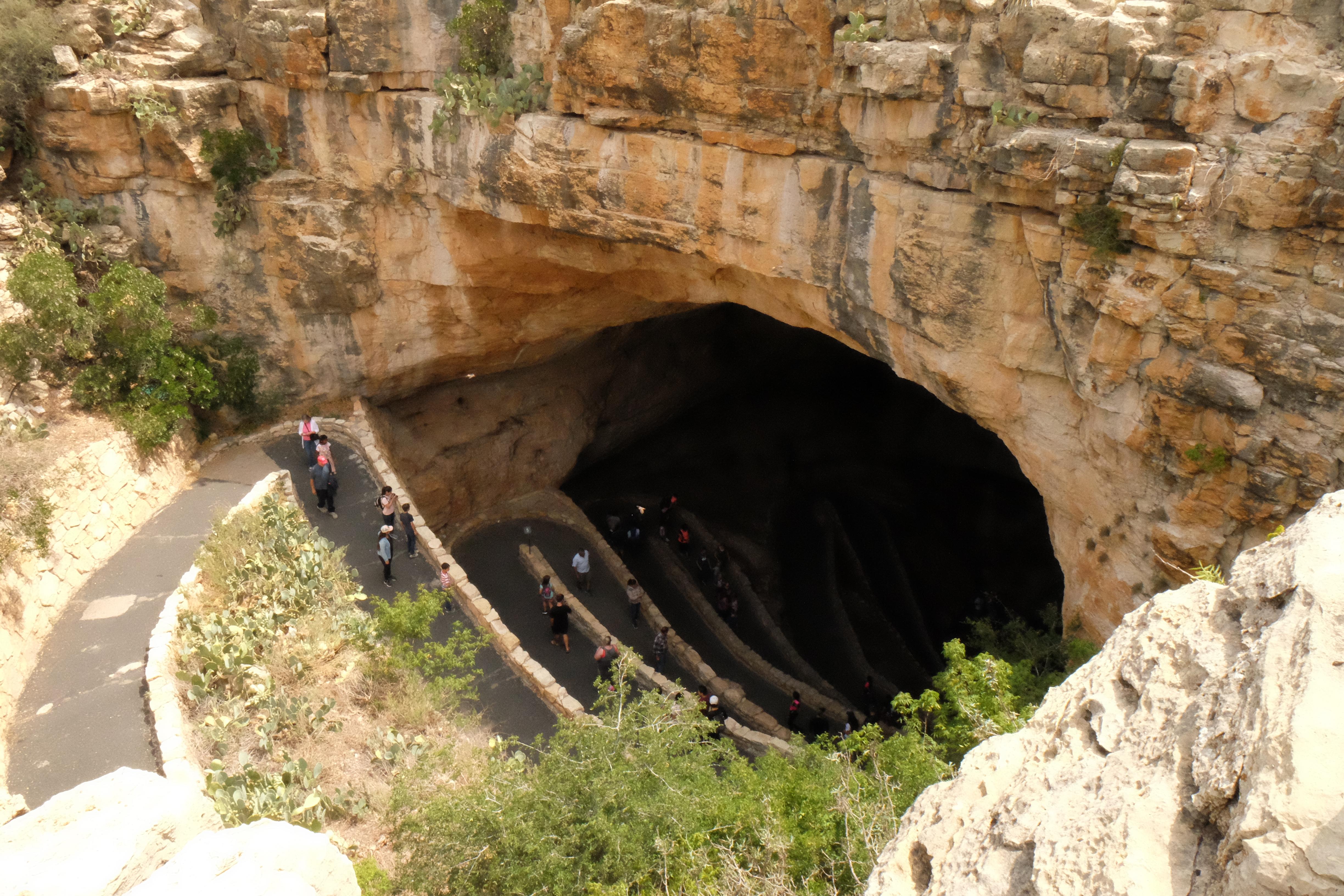 Photo of the Natural Entrance to Carlsbad Cavern with visitors hiking down the trail.
