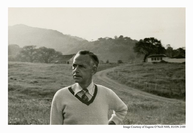 Eugene O'Neill, and older man, poses outside against a hilly background.