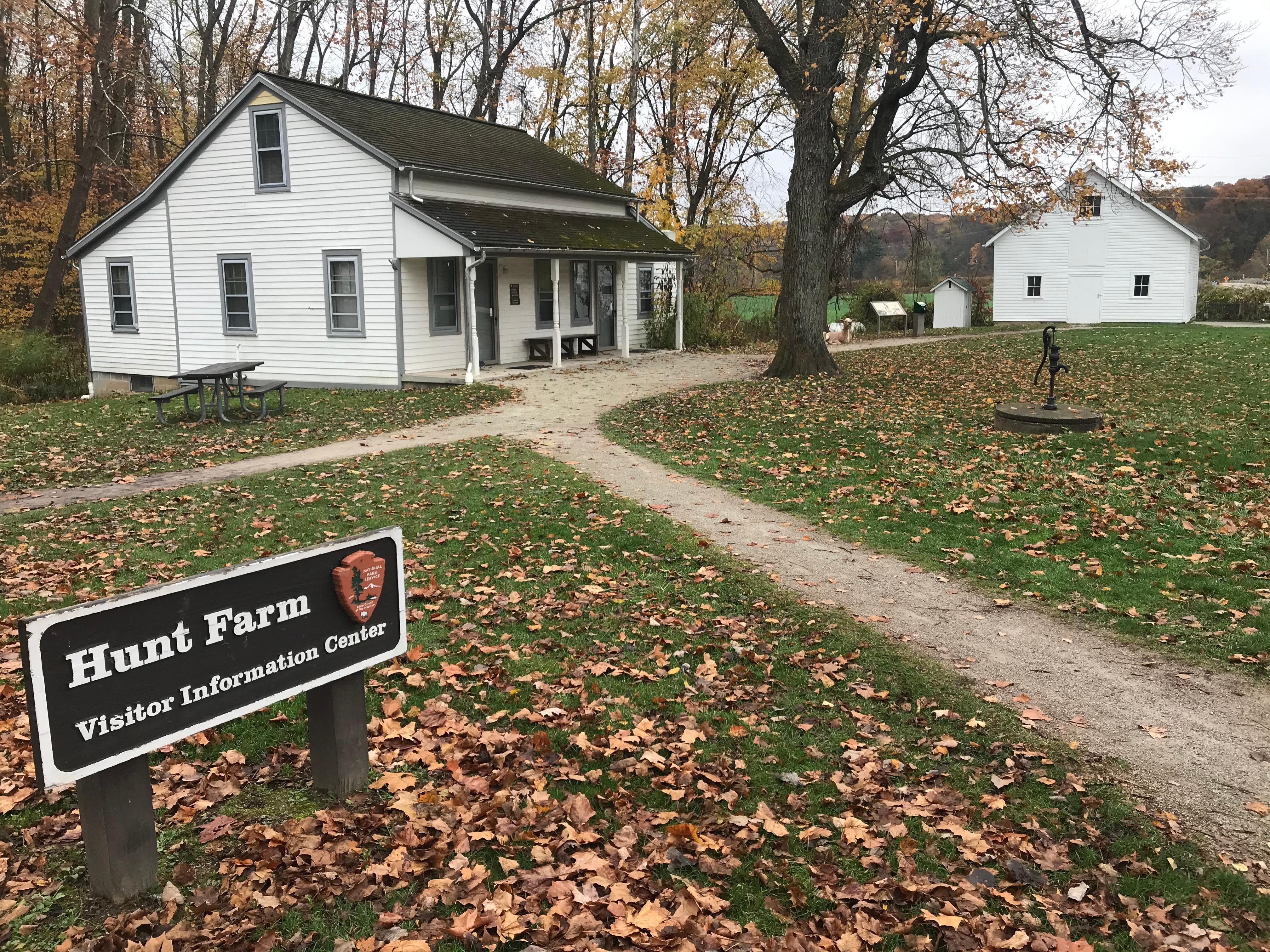 Exterior of two white buildings; a sign in front reads "Hunt Farm Visitor Information Center".