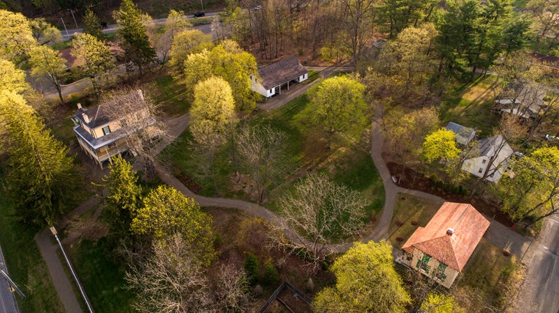 Thomas Cole Site Campus A bird's eye view of several buildings nested among trees and lawn.