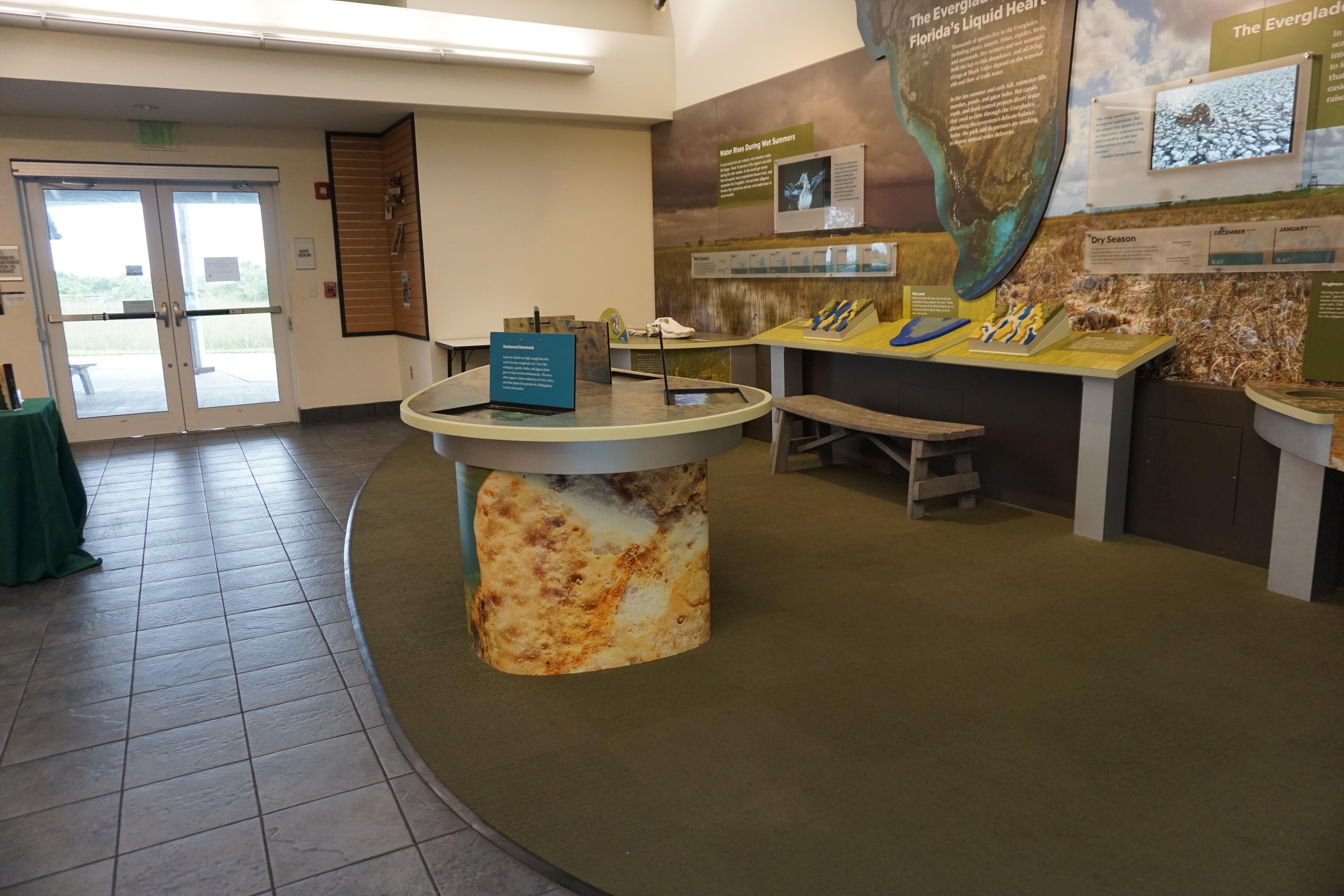 Colorful table top interpretive and touch displays sit in a small museum
