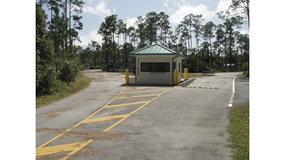 A white fees building with green roof welcomes campers