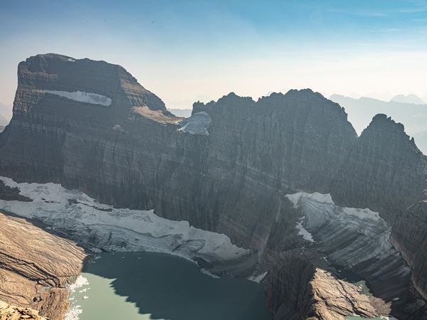 Grinnell Glacier in 2025, a shrinking mountain glacier above a turquoise lake with peaks behind.