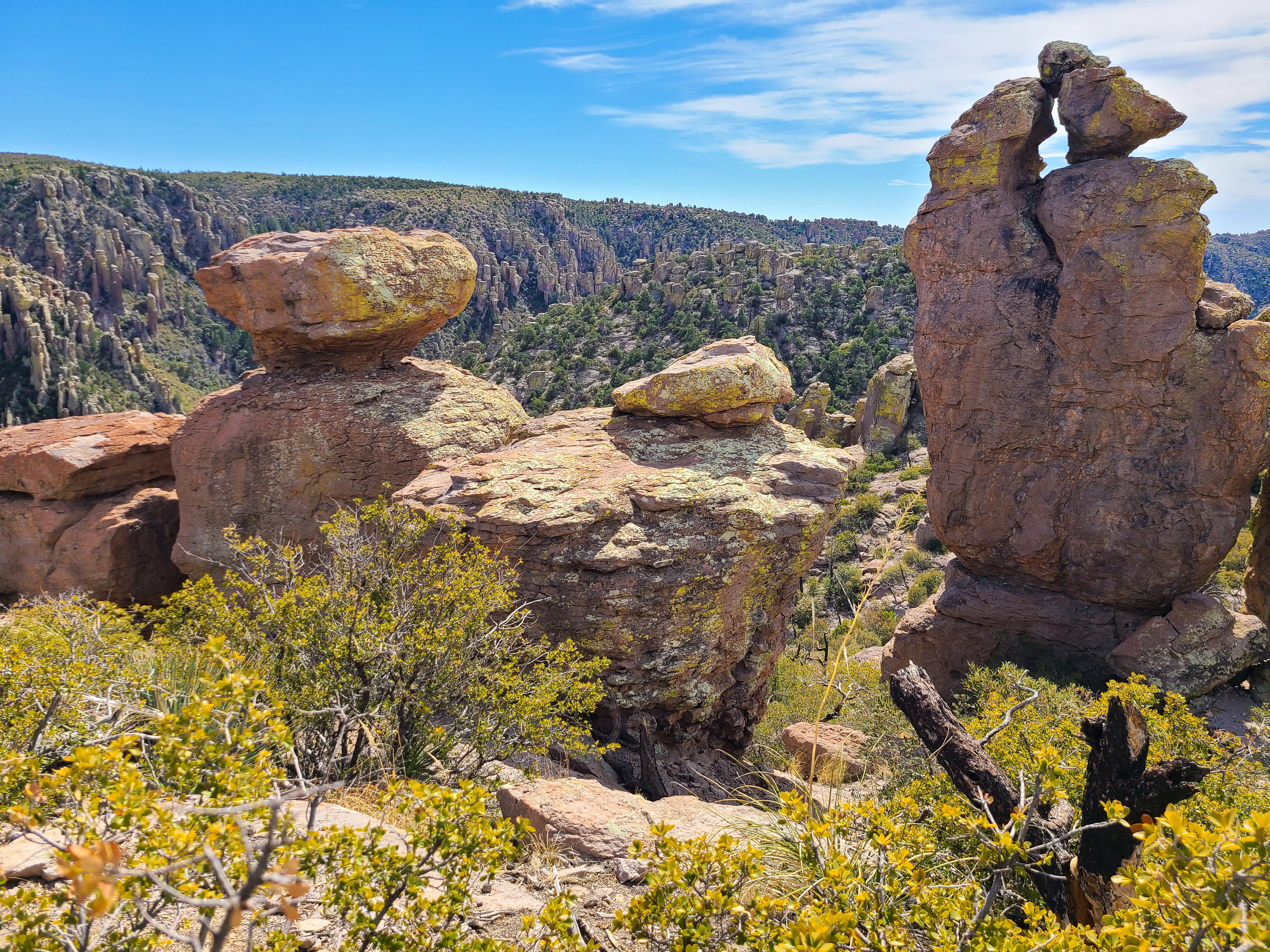 enormous balanced rocks with many pinnacles behind and trees in front