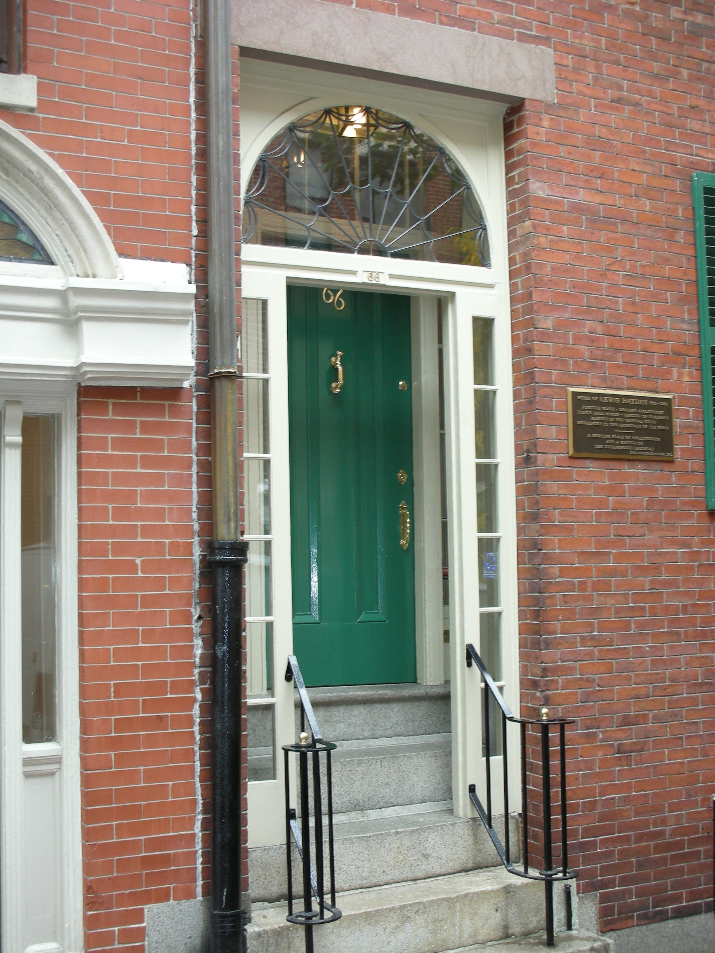 The entrance door into a red brick townhouse on Beacon Hill