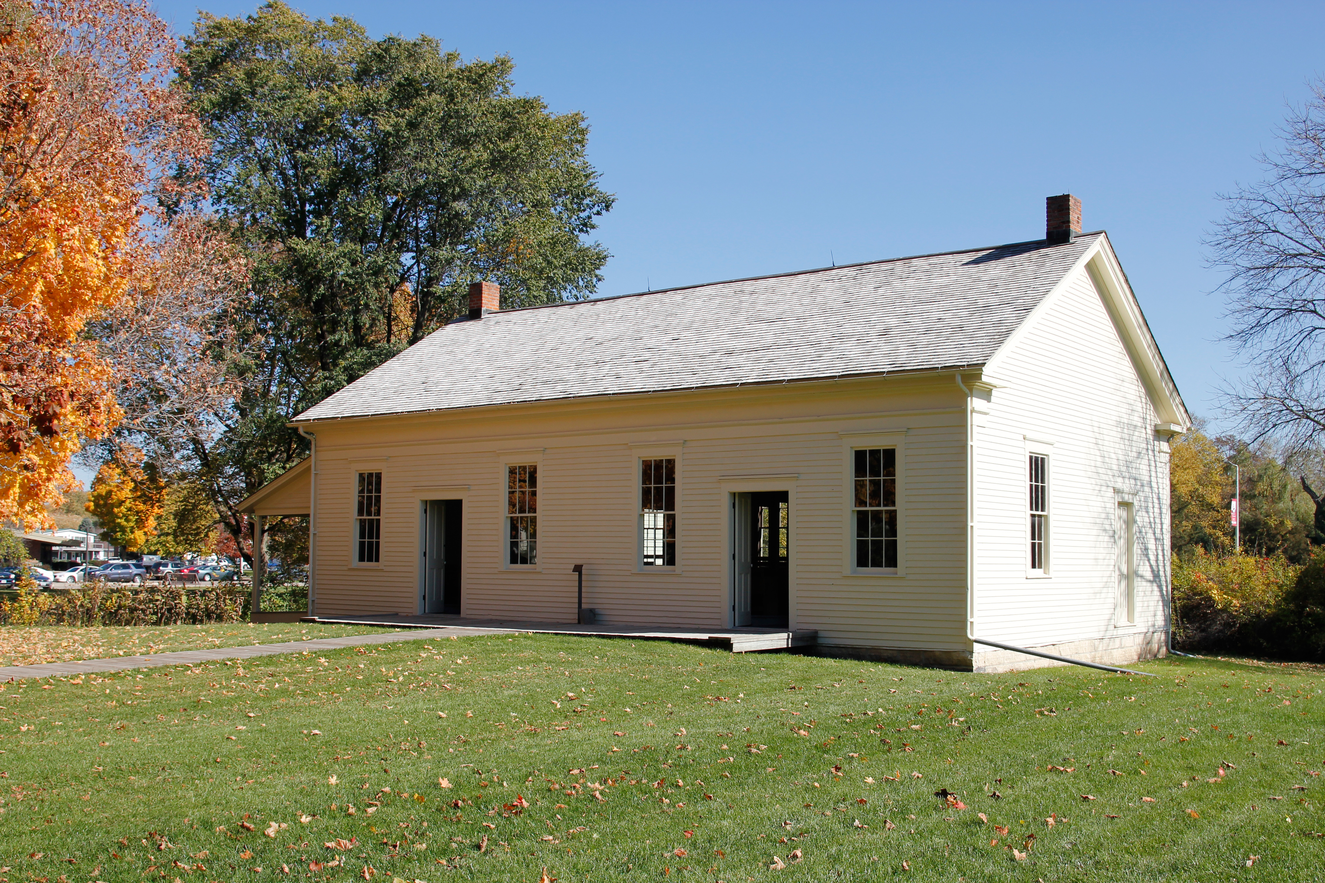 Two doorways, one on either side, of a broad white wood frame building divides the sexes.