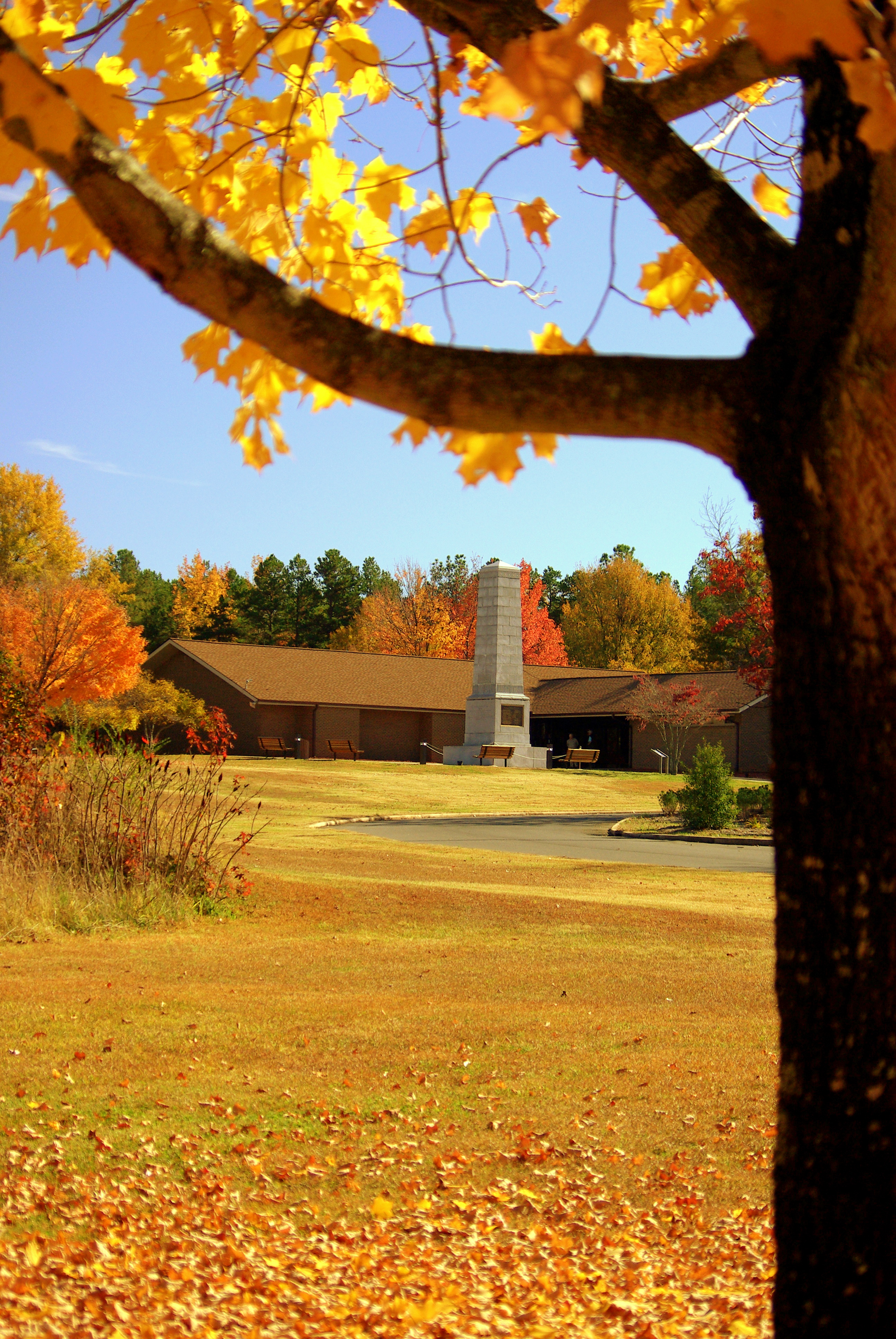 The Visitor Center and US Monument are framed by orange and yellow trees.