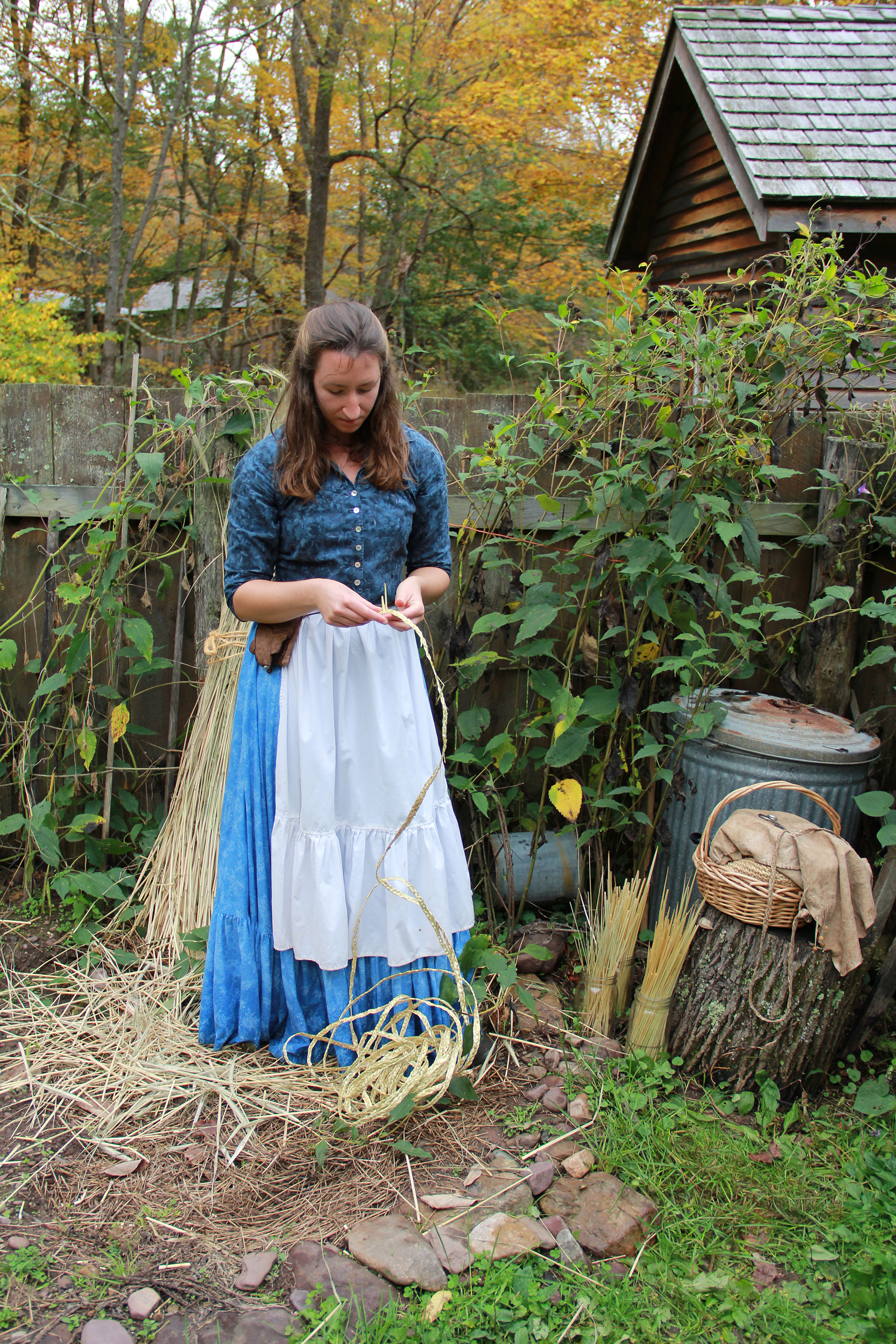 A woman braids rye straw for hatmaking