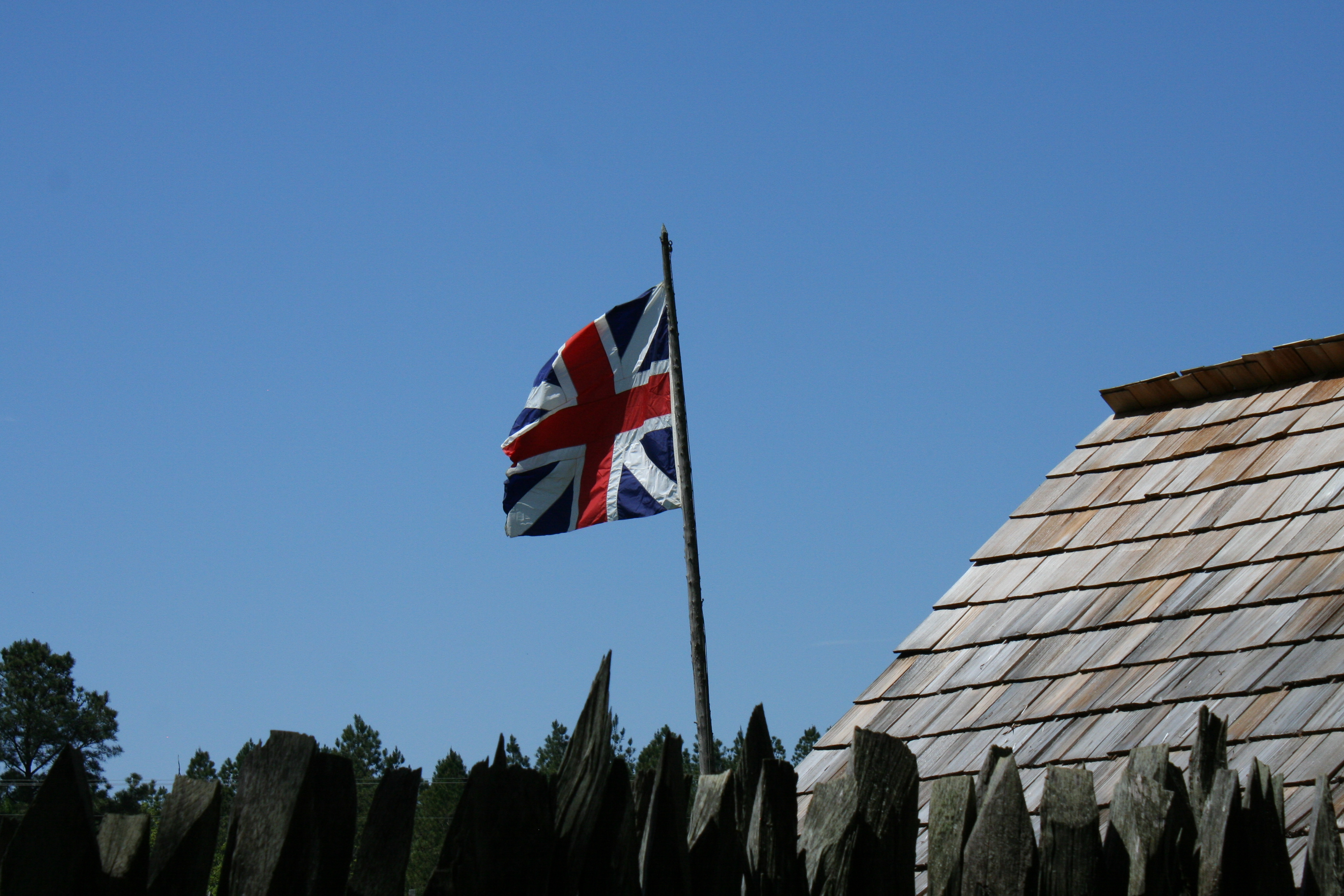A British flag flies over the stockade fort.