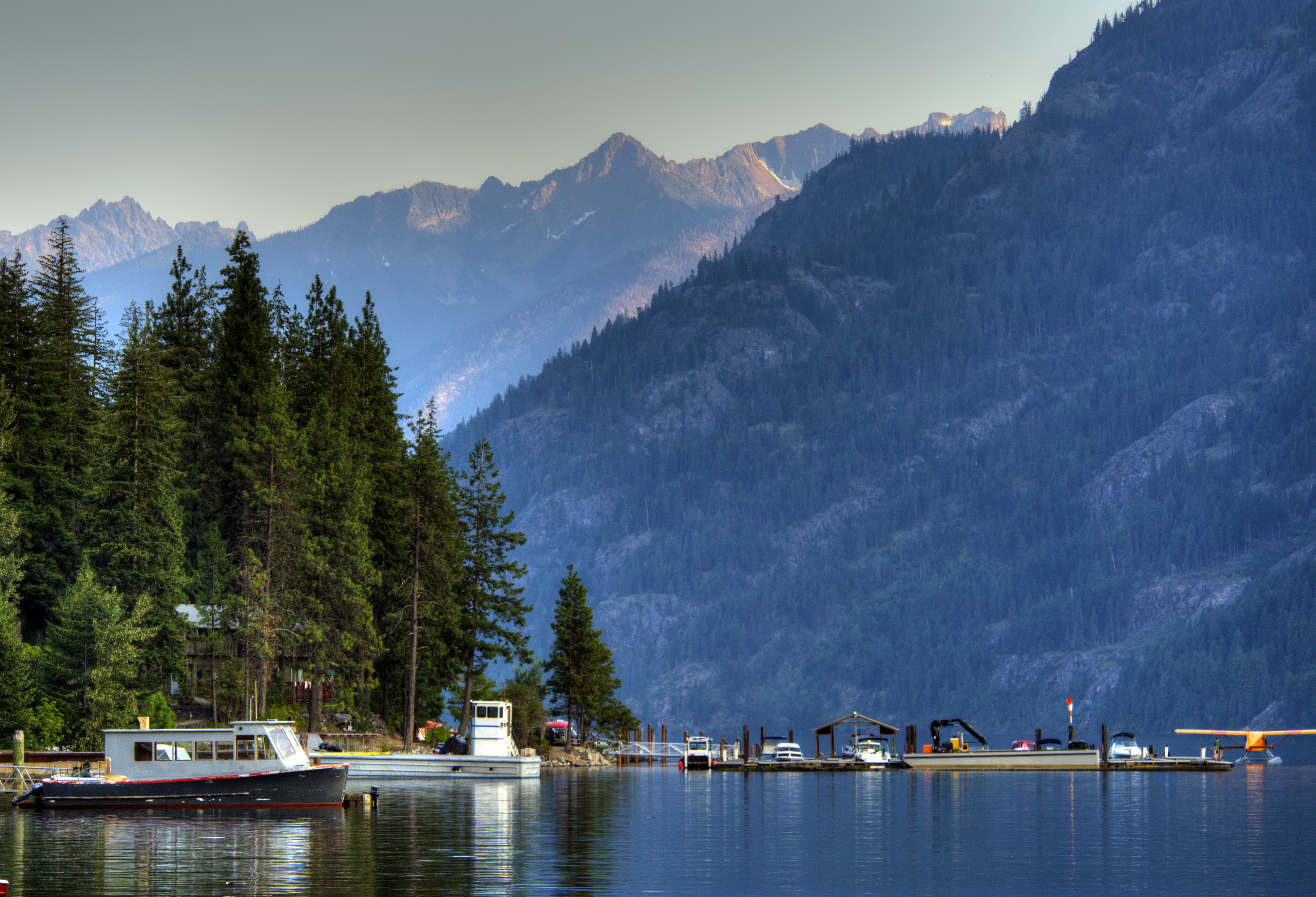 boats on the water with mountains and trees surrounding