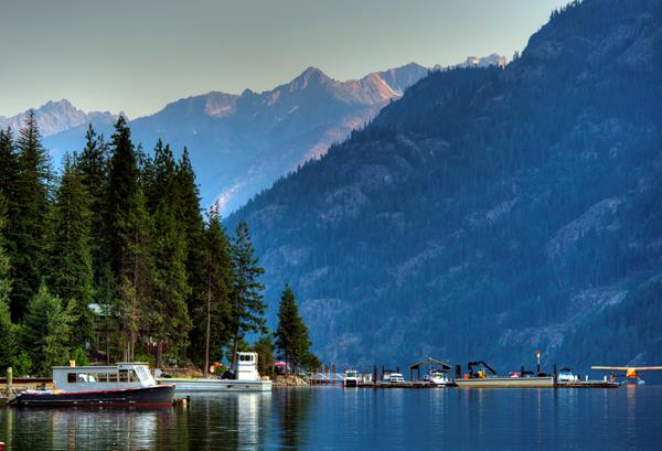 boats on the water with mountains and trees surrounding