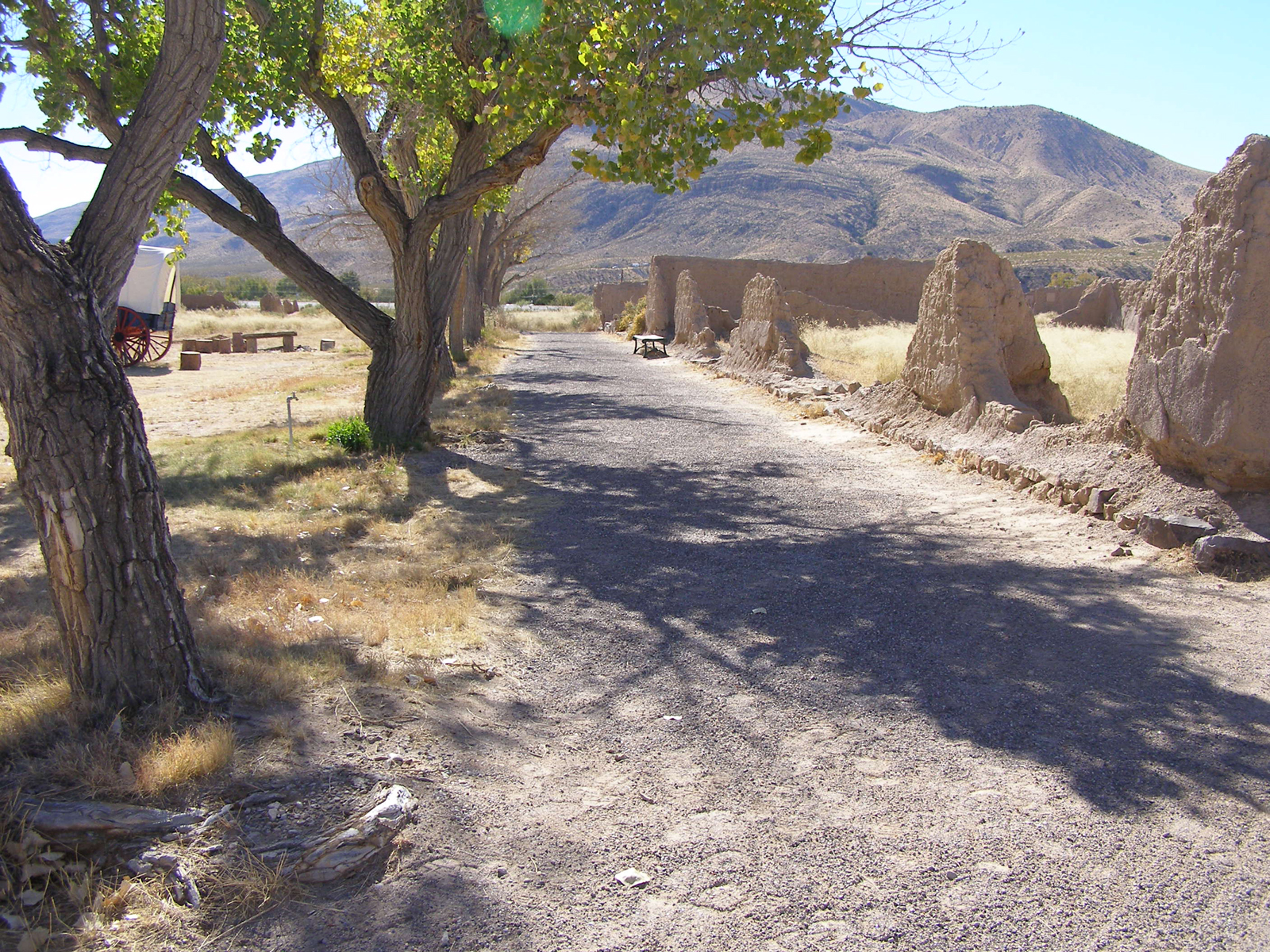 fort ruins in the sunlight with cottonwood trees on the left