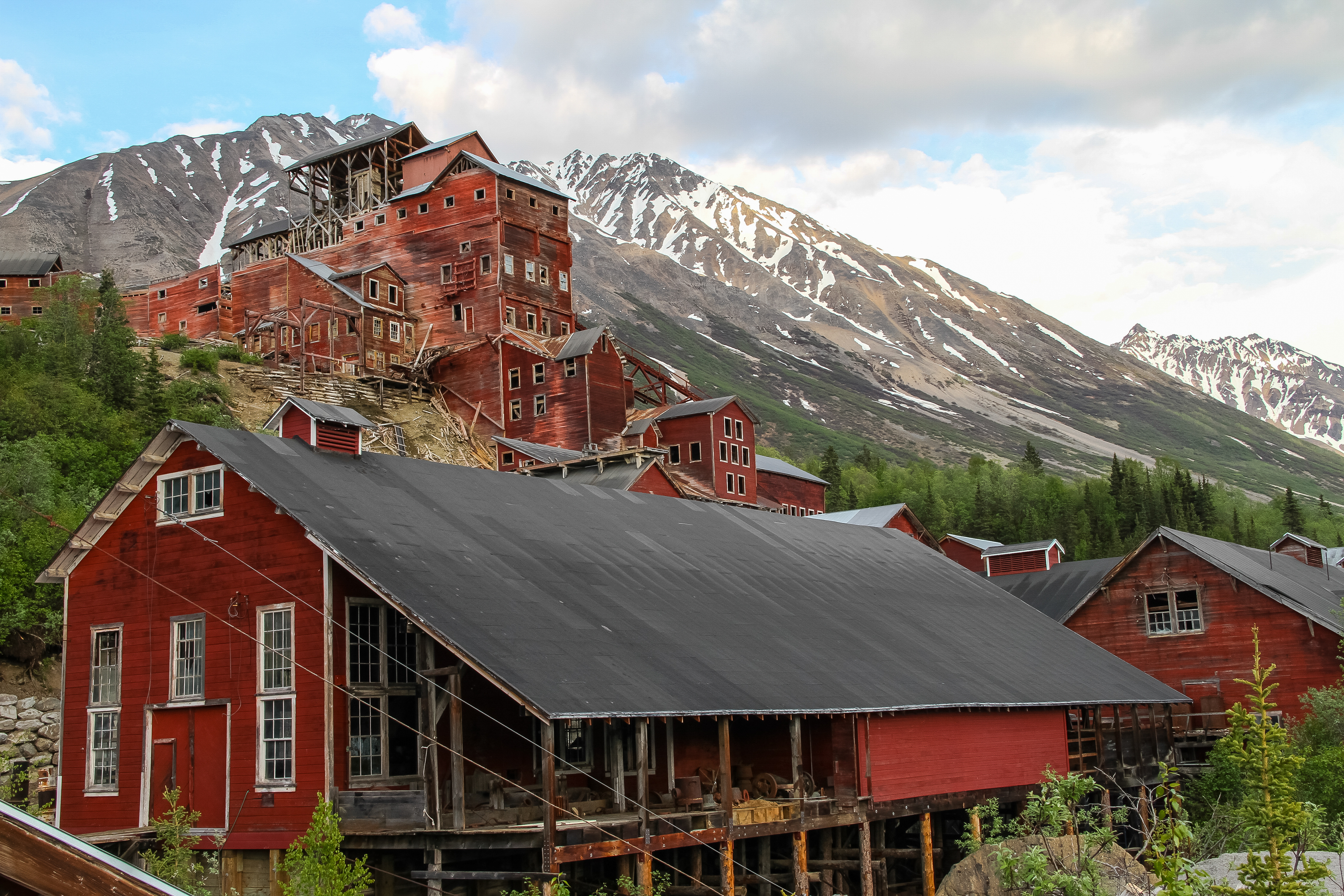 Historic, large, red buildings with mountains in the background