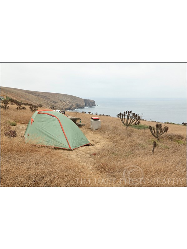 Small tent perched on bluff overlooking the ocean.