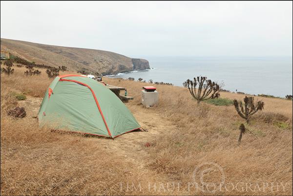 Small tent perched on bluff overlooking the ocean.