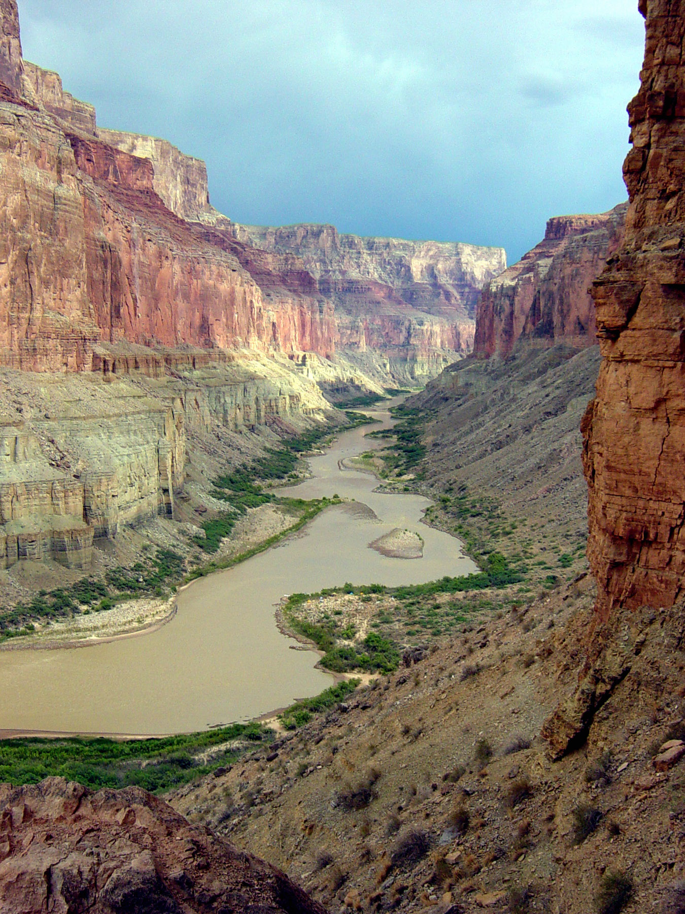 Tall canyon walls frame the wide Colorado river weaving back and forth.