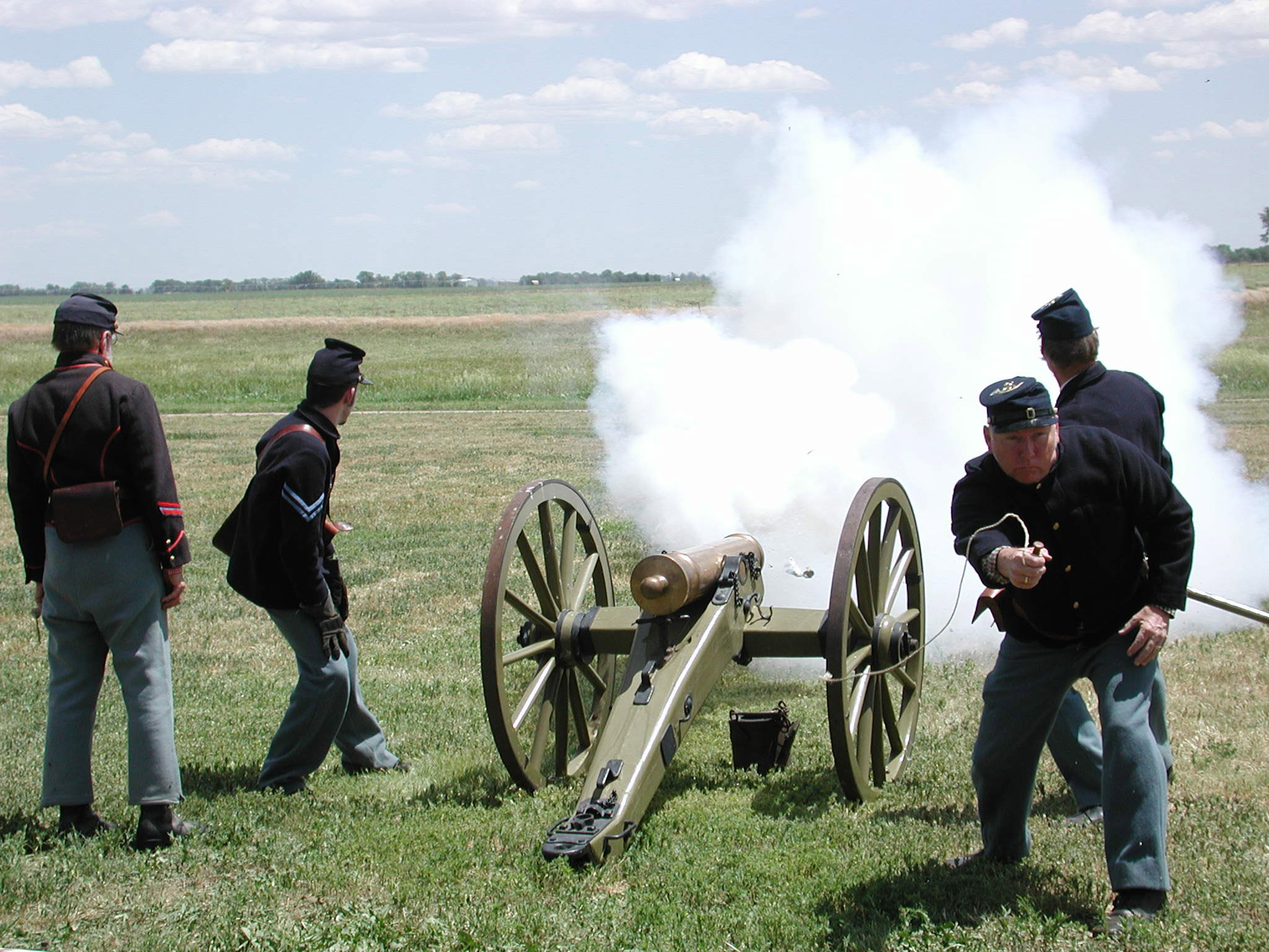 Men in 19th century U.S. Army uniforms fire a reproduction period cannon.