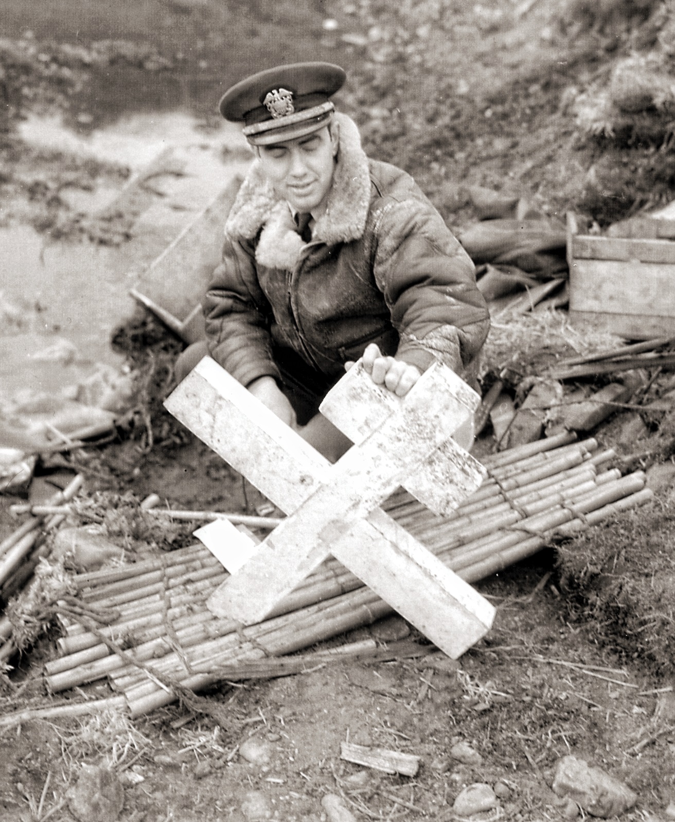 A uniformed man holds up a broken Russian cross