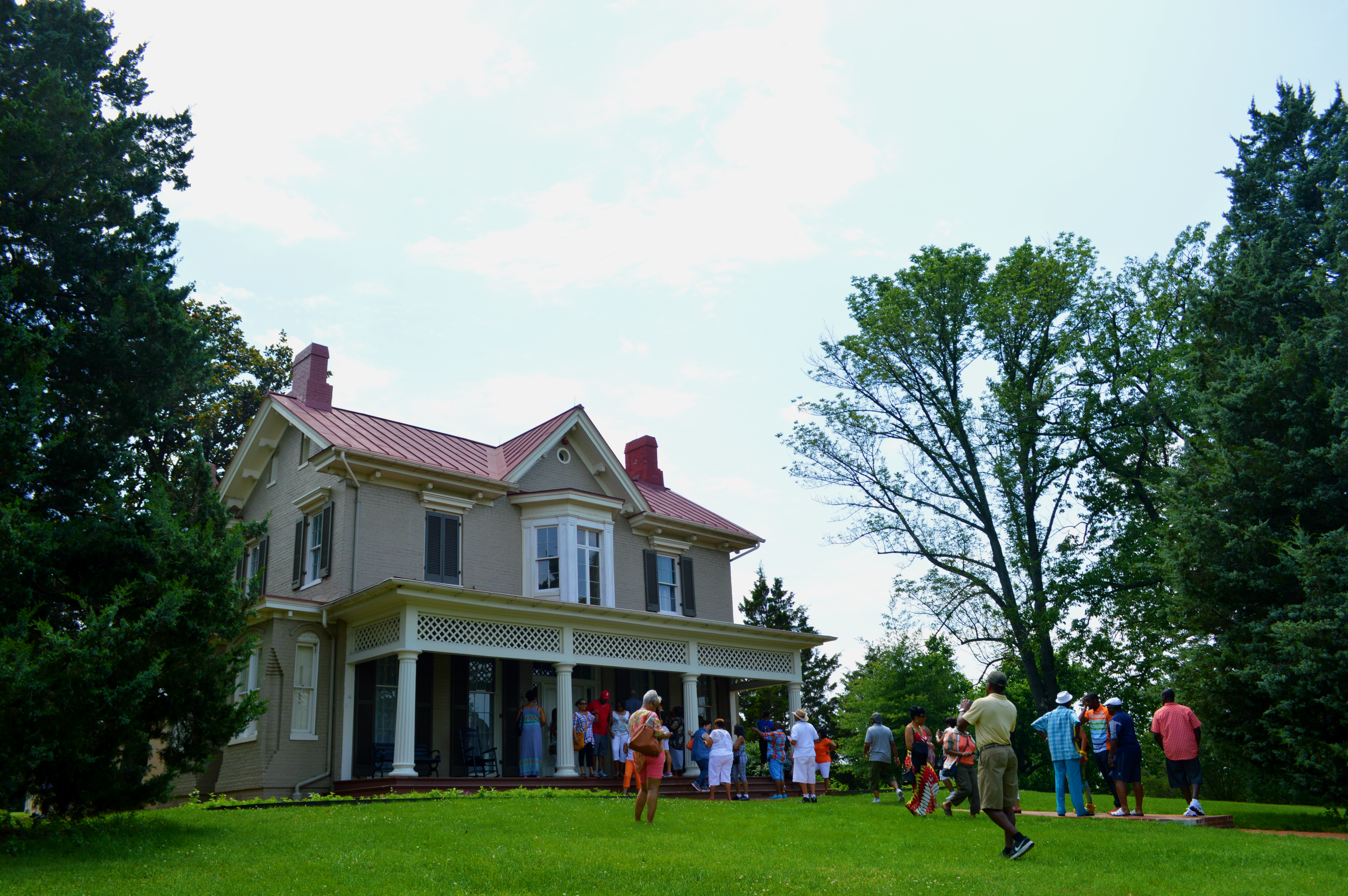 Visitors take photos in front of a historic house