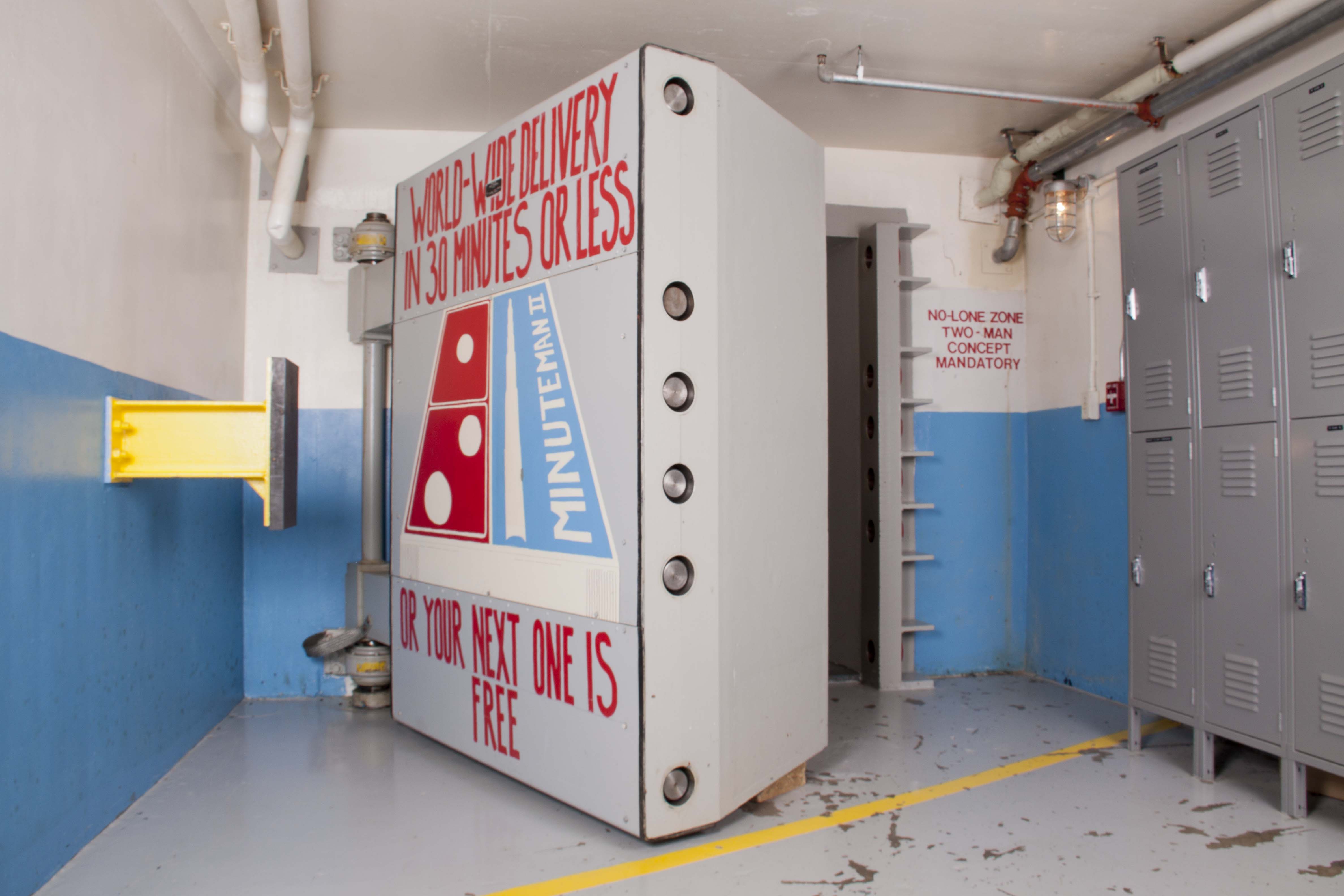 A large metal blast door with art of a Domino with a nuclear missile