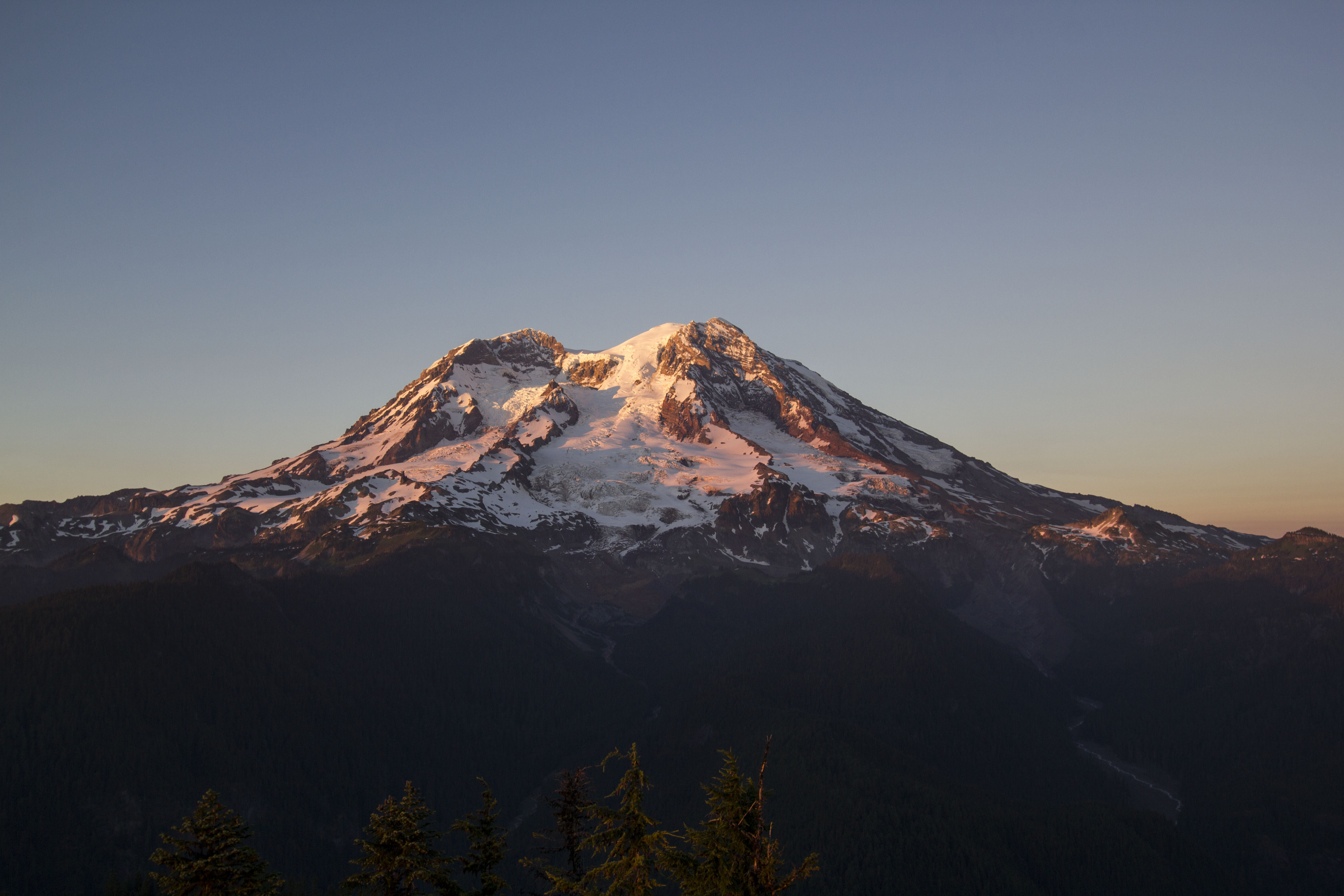 Sunset paints the glaciers of Mount Rainier in pink and gold.