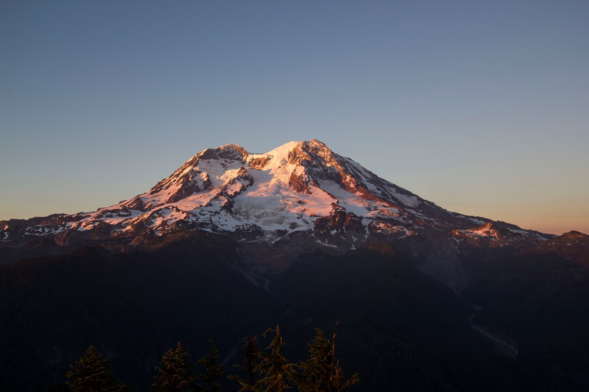 Sunset paints the glaciers of Mount Rainier in pink and gold.