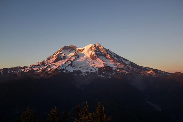 Sunset paints the glaciers of Mount Rainier in pink and gold.