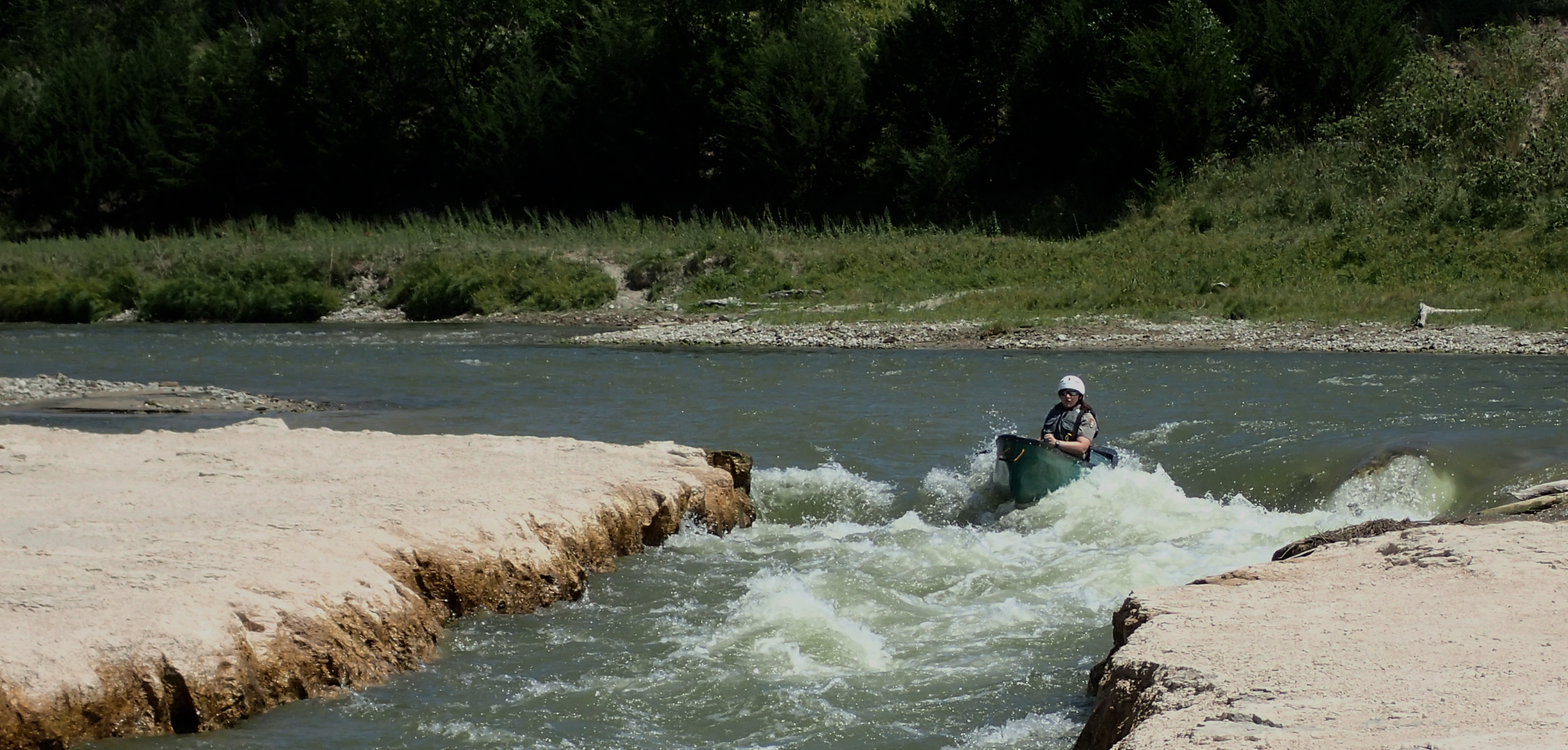 A paddler in a canoe goes through Class II Rapids on the Niobrara NSR.