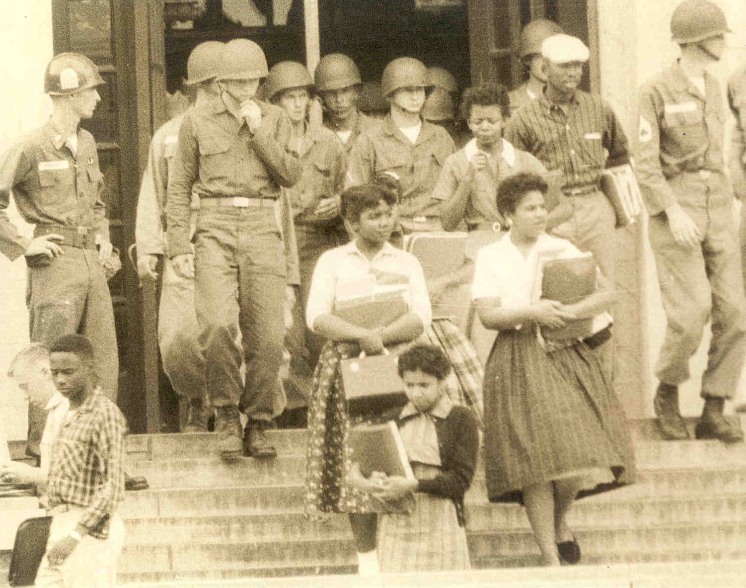 The Little Rock Nine exit the doors at Central High under troop escort