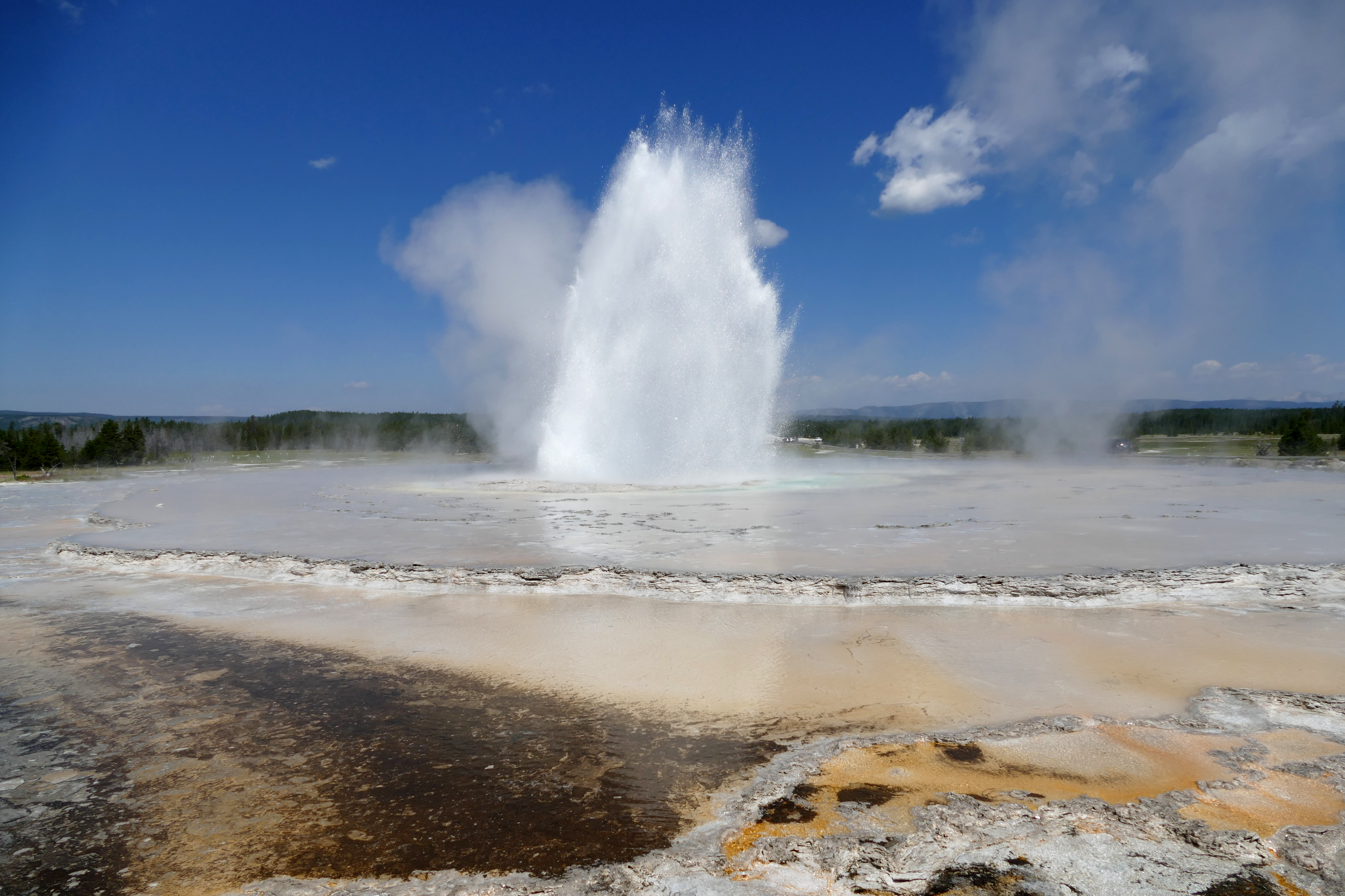 A geyser erupting in the middle of a large pool.