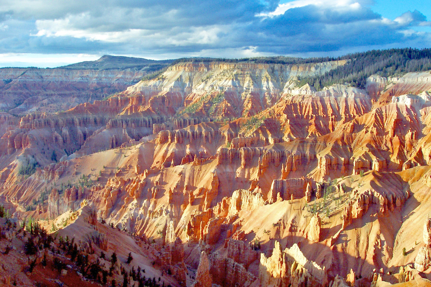 The ground falls away from the viewer creating brilliant rock formations of pink, red, and orange.