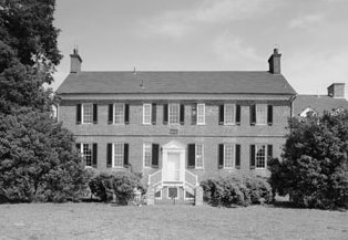 black and white photo of a large two story brick manor