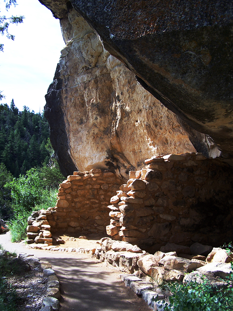 sunlight illuminates stone walls in a canyon cliff dwelling